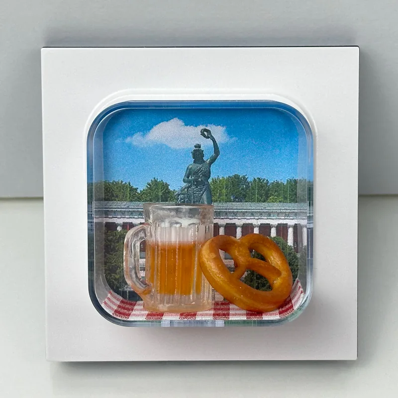 miarama Wiesn-Edition – Maßkrug und Brezn vor der Bavaria